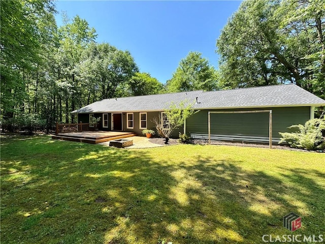 rear view of house with a yard and a deck