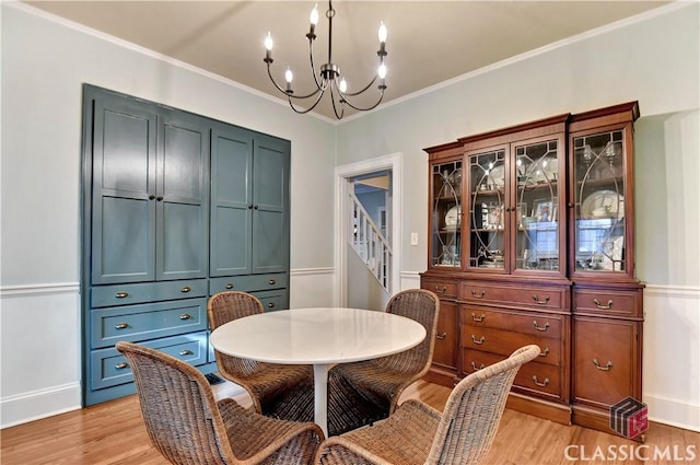 dining room with light wood-style floors, crown molding, and a chandelier