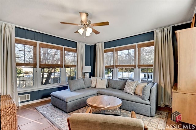 living room featuring a ceiling fan, tile patterned floors, and visible vents