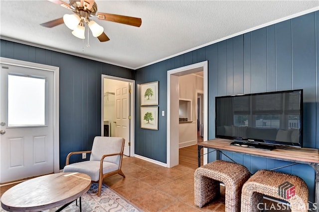 interior space with baseboards, a ceiling fan, a textured ceiling, and light tile patterned floors