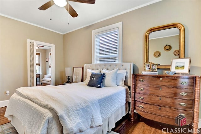 bedroom featuring crown molding, baseboards, a ceiling fan, and wood finished floors