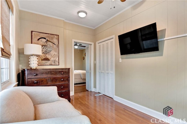 sitting room with baseboards, ornamental molding, ceiling fan, and wood finished floors