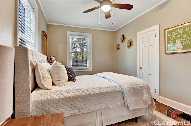 bedroom with crown molding, baseboards, ceiling fan, and wood finished floors