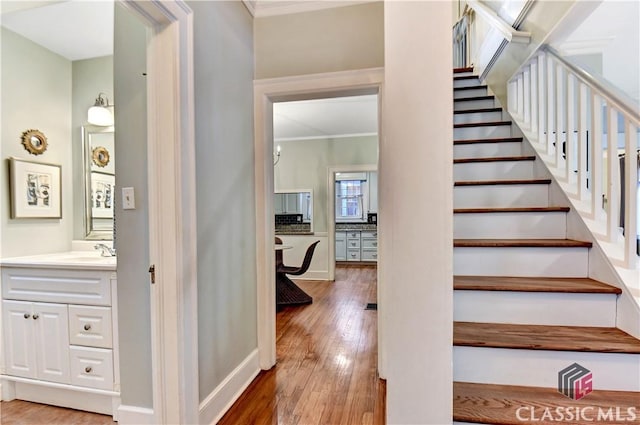 staircase with baseboards, ornamental molding, and hardwood / wood-style flooring