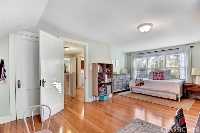 bedroom featuring light wood-style floors and baseboards