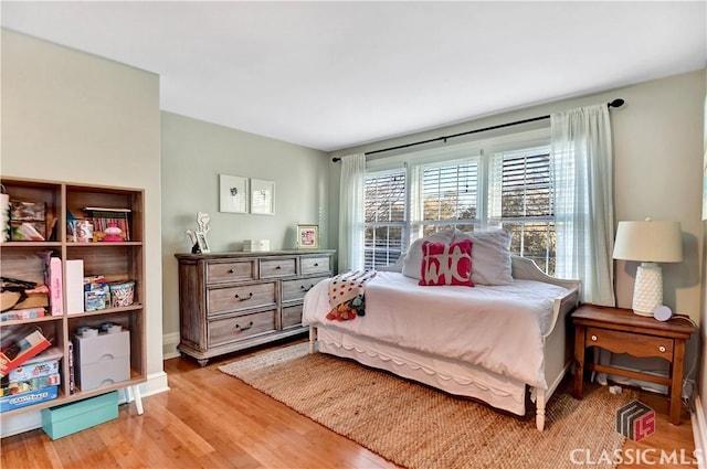 bedroom with baseboards and wood finished floors