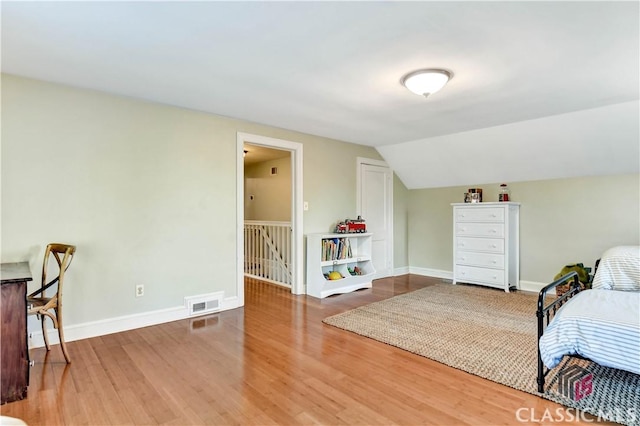 bedroom featuring baseboards, visible vents, and wood finished floors