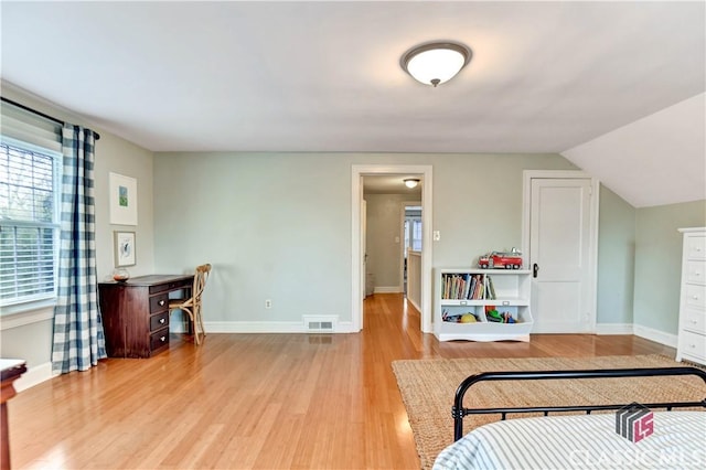 bedroom featuring light wood-type flooring, baseboards, visible vents, and multiple windows