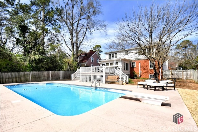 view of pool with a deck, a fenced backyard, stairs, a fenced in pool, and a patio area