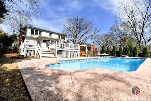 view of swimming pool featuring a deck, stairway, a fenced backyard, a fenced in pool, and a patio