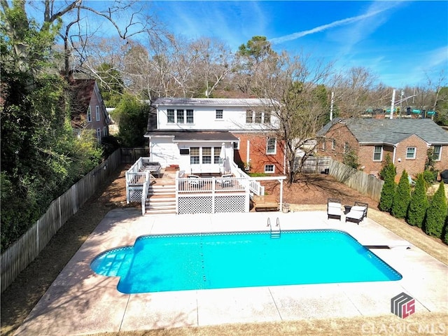view of pool featuring a deck, a fenced in pool, stairs, and a fenced backyard