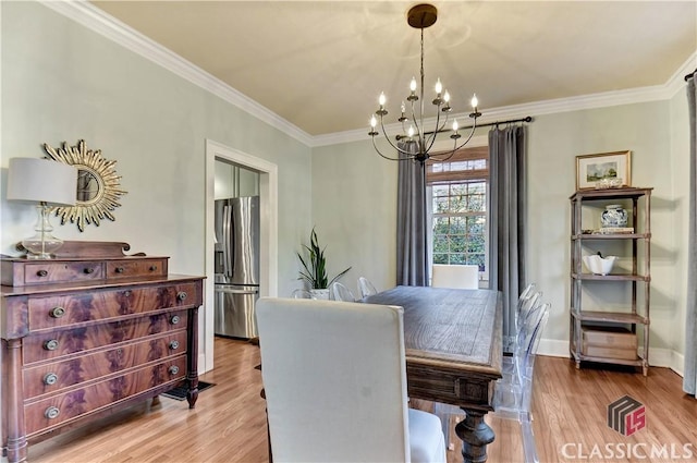 dining room featuring crown molding, baseboards, wood finished floors, and a chandelier