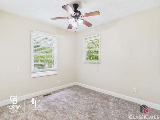 empty room featuring baseboards, a ceiling fan, carpet, and visible vents
