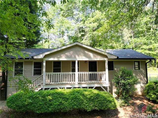 ranch-style home featuring covered porch and a shingled roof