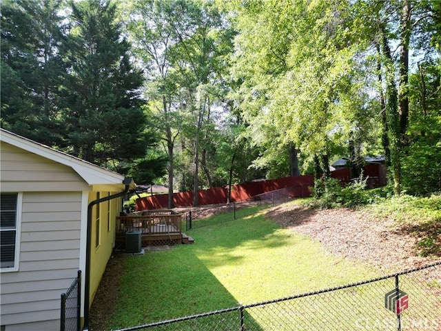 view of yard with a deck, central AC unit, and a fenced backyard