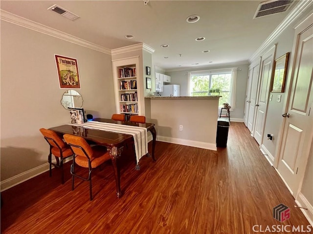 dining area with visible vents, dark wood finished floors, crown molding, and baseboards