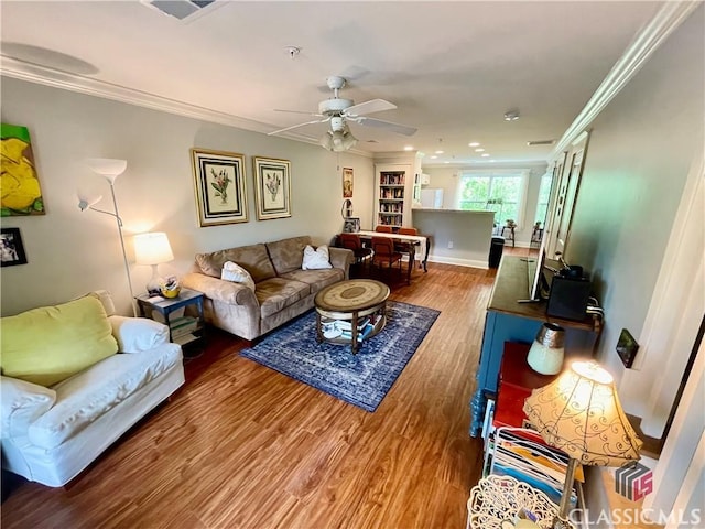 living area featuring ornamental molding, a ceiling fan, wood finished floors, and visible vents