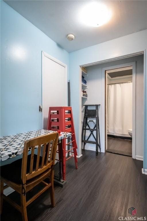 dining space featuring baseboards and dark wood-style flooring