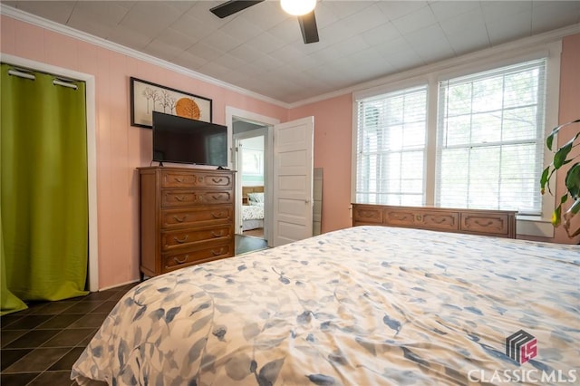 bedroom featuring crown molding, dark tile patterned flooring, and a ceiling fan