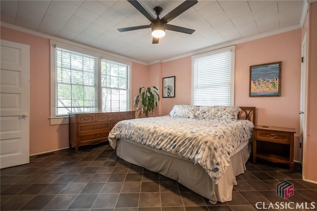 bedroom featuring dark tile patterned floors, ornamental molding, and a ceiling fan
