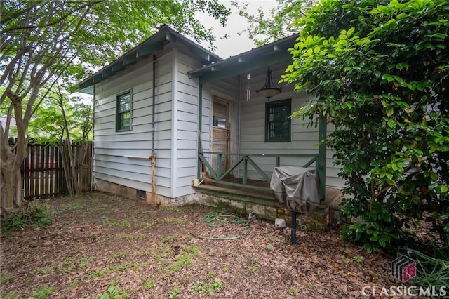 view of property exterior with crawl space and fence