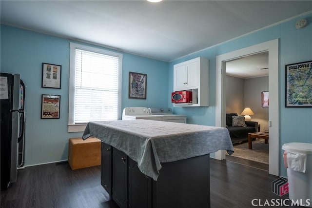 bedroom with freestanding refrigerator, baseboards, dark wood-style floors, and washing machine and clothes dryer