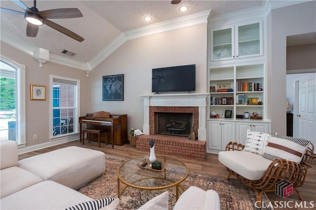 living room featuring crown molding, ceiling fan, wood finished floors, and visible vents