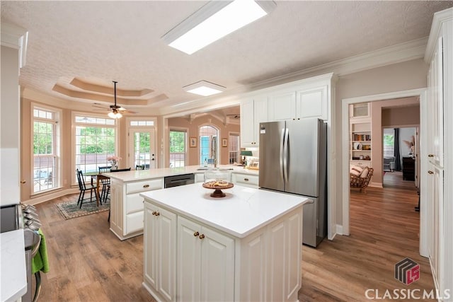 kitchen featuring light countertops, a kitchen island, stainless steel appliances, and a peninsula