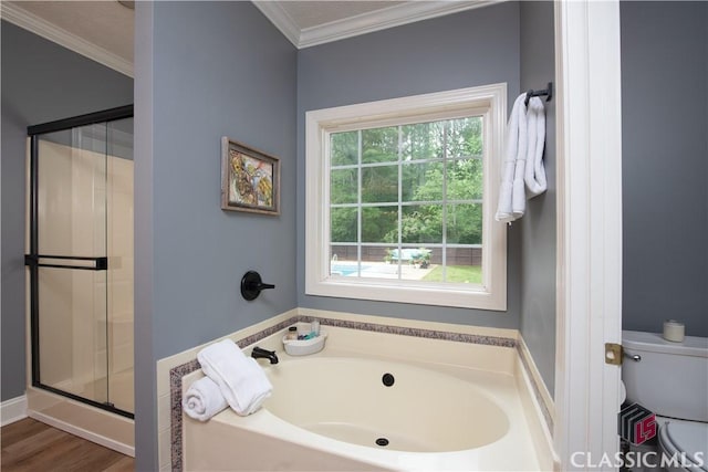 full bathroom featuring crown molding, a garden tub, wood finished floors, toilet, and a stall shower
