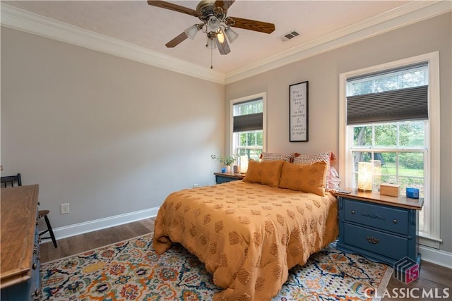 bedroom featuring visible vents, baseboards, crown molding, and wood finished floors