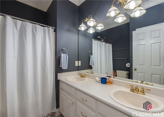 bathroom featuring double vanity, a sink, toilet, and ornamental molding