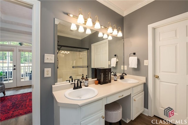 full bath featuring walk in shower, a sink, french doors, wood finished floors, and ornamental molding