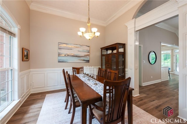 dining space with an inviting chandelier, crown molding, and dark wood-style floors