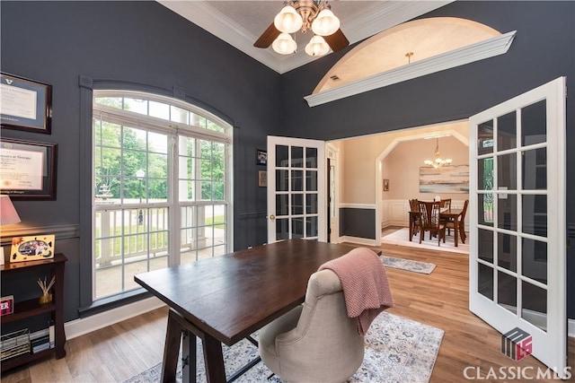 dining room featuring ornamental molding, ceiling fan with notable chandelier, and wood finished floors