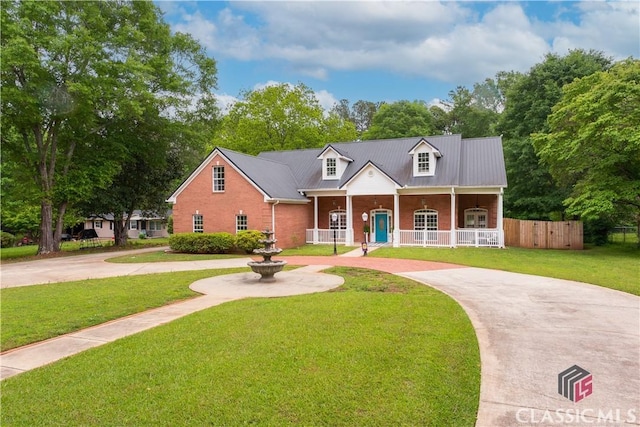 view of front of property with fence, curved driveway, a porch, and a front lawn