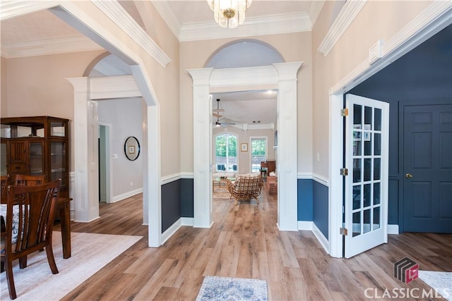 foyer entrance featuring baseboards, ornamental molding, light wood-style flooring, and a ceiling fan