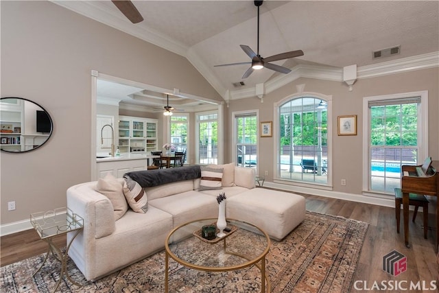 living area with visible vents, dark wood finished floors, ceiling fan, and a wealth of natural light