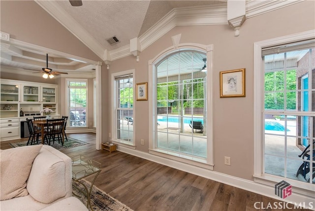 entryway with crown molding, ceiling fan, lofted ceiling, and visible vents