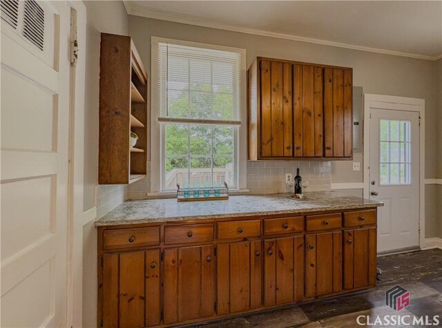 1114 S Broad St, Monroe, GA 30655 - kitchen featuring crown molding, open shelves, backsplash, and brown cabinets
