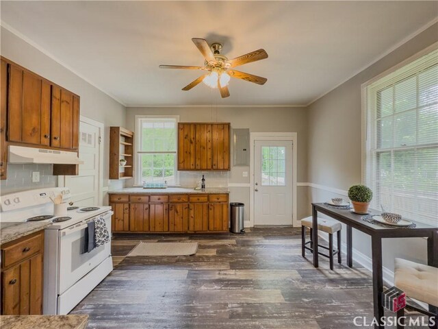1114 S Broad St, Monroe, GA 30655 - kitchen featuring plenty of natural light, white range with electric cooktop, under cabinet range hood, and brown cabinets