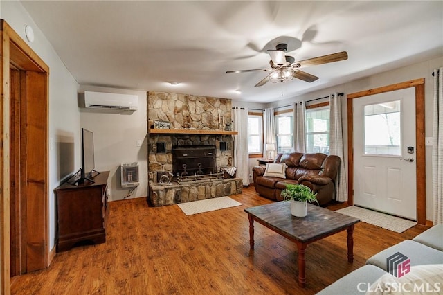 50 Atlanta Ln, Clayton, GA 30525 - living area featuring ceiling fan, a stone fireplace, heating unit, a wall unit AC, and wood finished floors