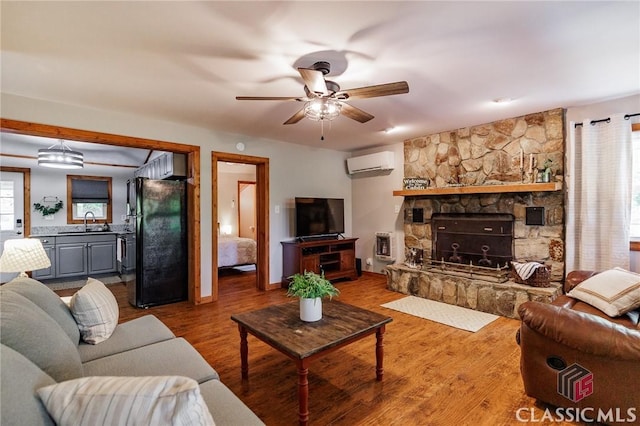 50 Atlanta Ln, Clayton, GA 30525 - living room featuring wood finished floors, ceiling fan, a wall mounted AC, and a fireplace