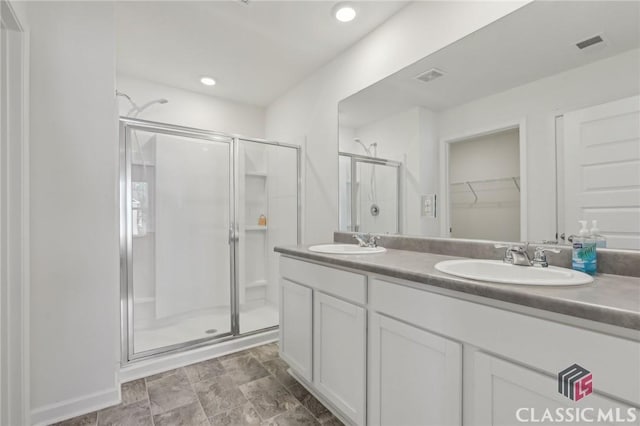 full bathroom featuring double vanity, a sink, visible vents, and a shower stall