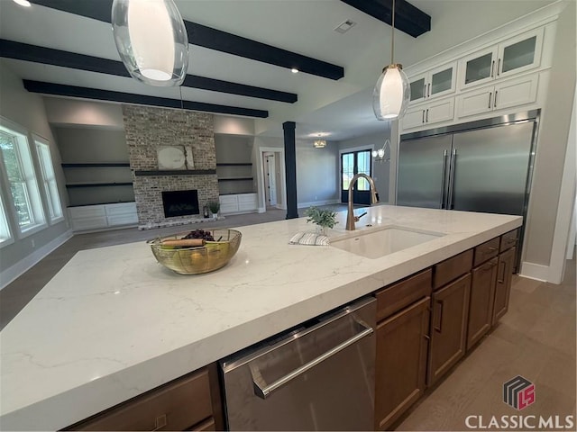 1200 Askew Trl, Greensboro, GA 30642 - kitchen with stainless steel appliances, beamed ceiling, open floor plan, glass insert cabinets, and a brick fireplace