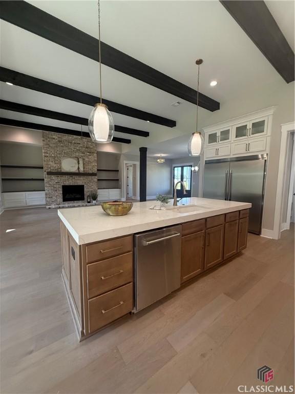 1200 Askew Trl, Greensboro, GA 30642 - kitchen featuring appliances with stainless steel finishes, open floor plan, light wood-style floors, light countertops, and beam ceiling