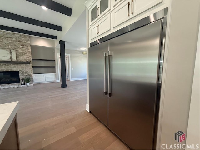 1200 Askew Trl, Greensboro, GA 30642 - kitchen with built in fridge, white cabinetry, light wood-type flooring, glass insert cabinets, and light countertops