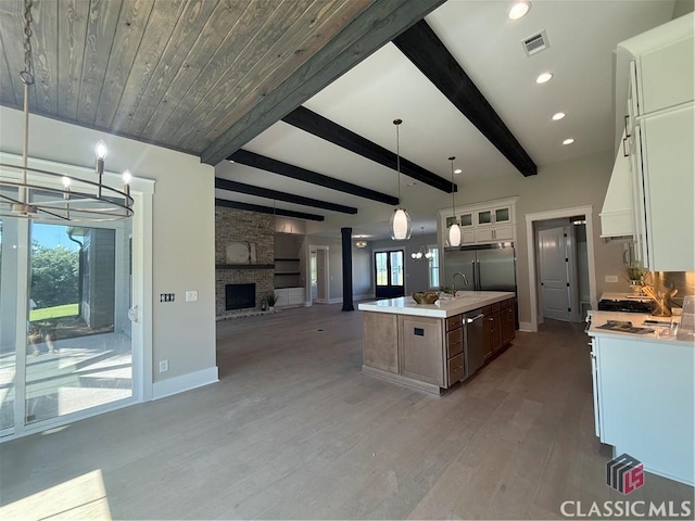1200 Askew Trl, Greensboro, GA 30642 - kitchen featuring appliances with stainless steel finishes, open floor plan, light wood-style floors, light countertops, and beam ceiling