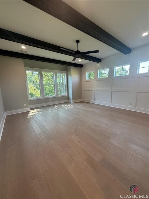 1200 Askew Trl, Greensboro, GA 30642 - spare room with beamed ceiling, a ceiling fan, healthy amount of natural light, light wood-style flooring, and a decorative wall