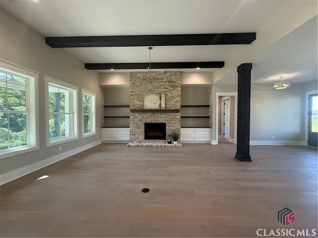 1200 Askew Trl, Greensboro, GA 30642 - unfurnished living room with wood finished floors, beamed ceiling, and a fireplace