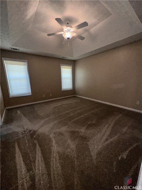 spare room with baseboards, a textured ceiling, carpet, and ceiling fan